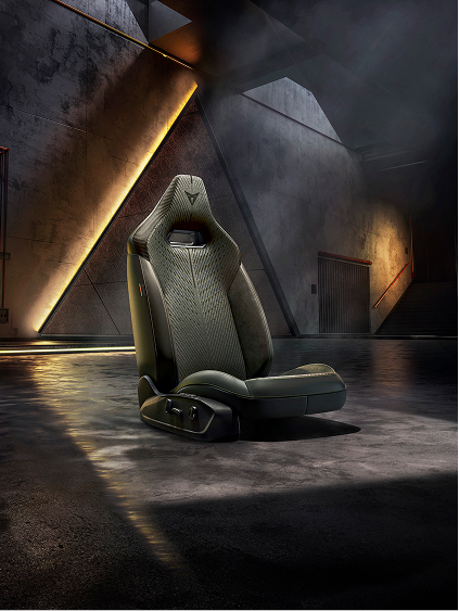 CUPRA Performance-Sitz freigestellt in einer dunklen Industriekulisse mit warmen Lichtreflexen auf dem Boden